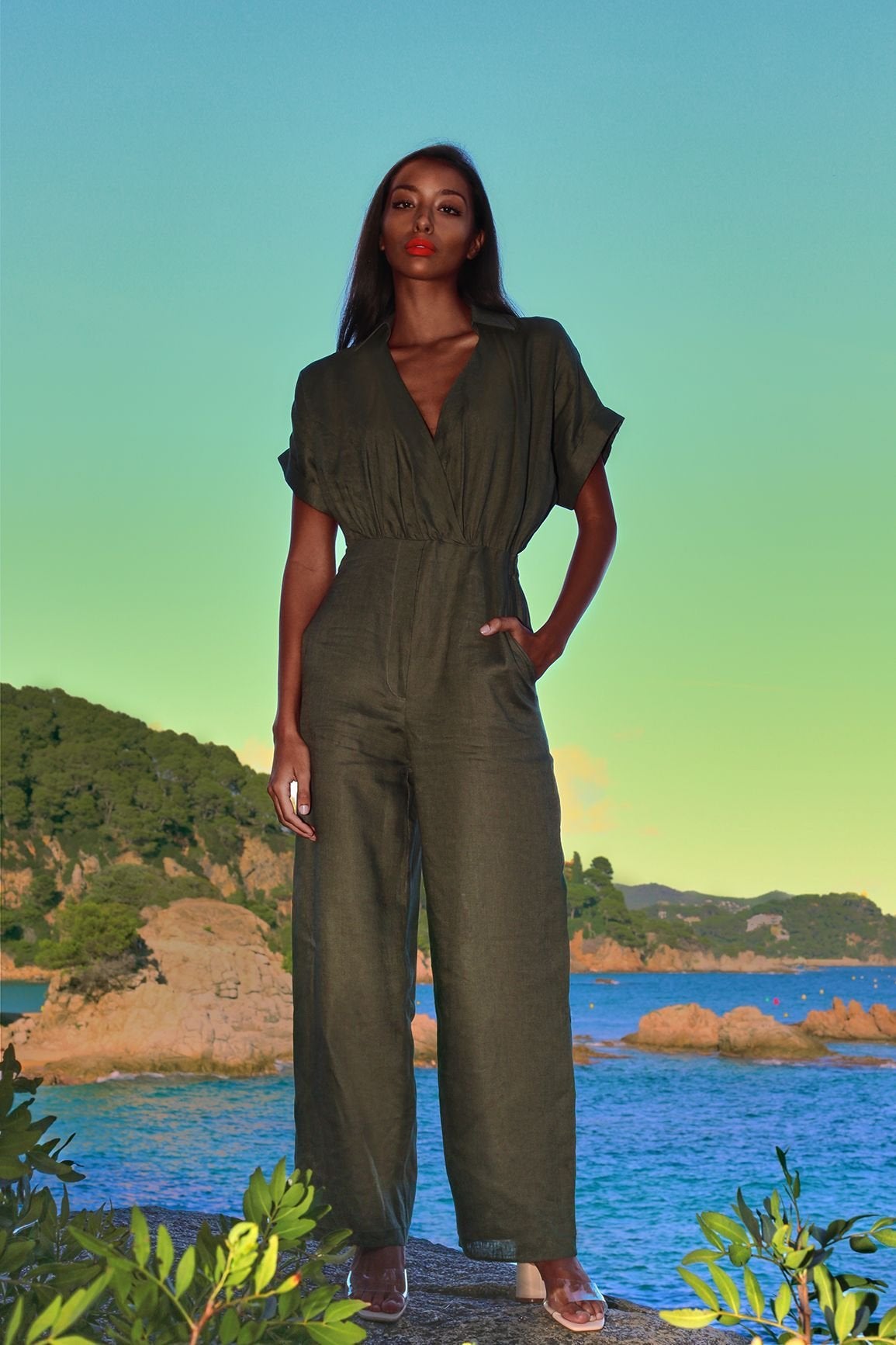 Green linen wrap jumpsuit with V-neck and elastic waist.