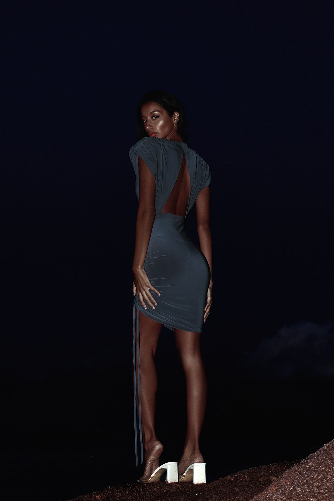 Dark grey cocktail dress with backless design and chic shoulder pads.