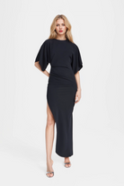 Jade Asymmetric Long Dress in black with thigh-high side slit and pleated waist.