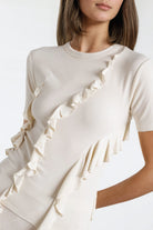 Off-white short-sleeve top featuring unique fringe for a trendy look.