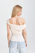 Modern beige one-shoulder top with a sleek, fitted silhouette.