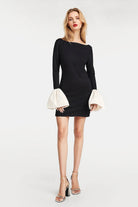 Chic black minidress featuring unique taffeta-trimmed cuffs and gathered off-white detailing