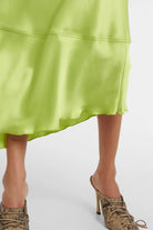 Flattering green satin dress featuring long sleeves and a cinched waist.