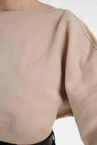 Lisa Cropped Organic Cotton Fleece Sweatshirt in beige with dropped shoulders.