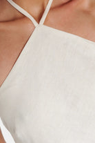 Fitted off-white halterneck dress showcasing premium linen fabric.